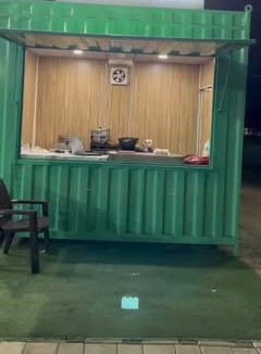 The green Ma se Momos outlet at Ratibad, lit up at night