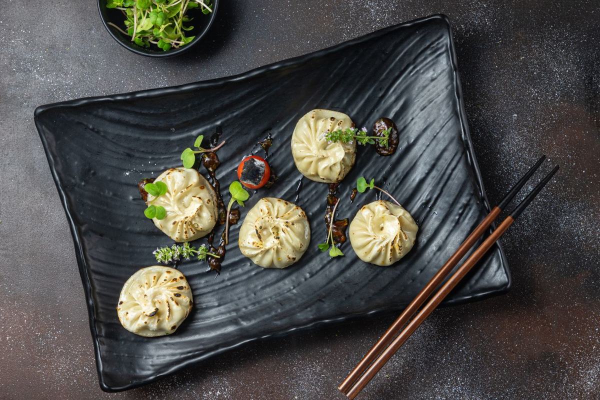 Momo platter with dips on a dark plate